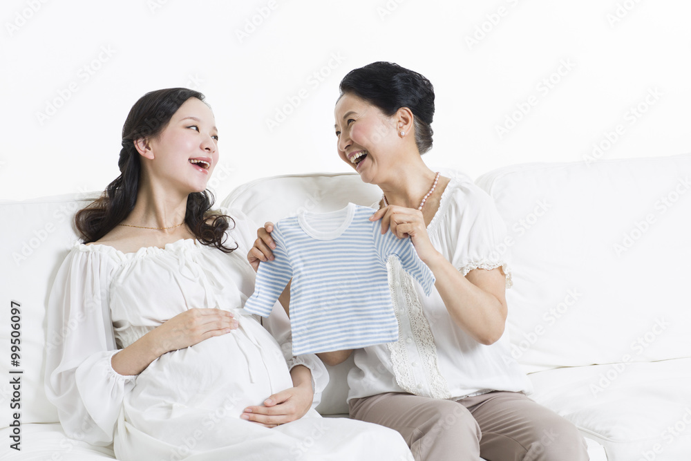 Mother and daughter preparing baby clothing