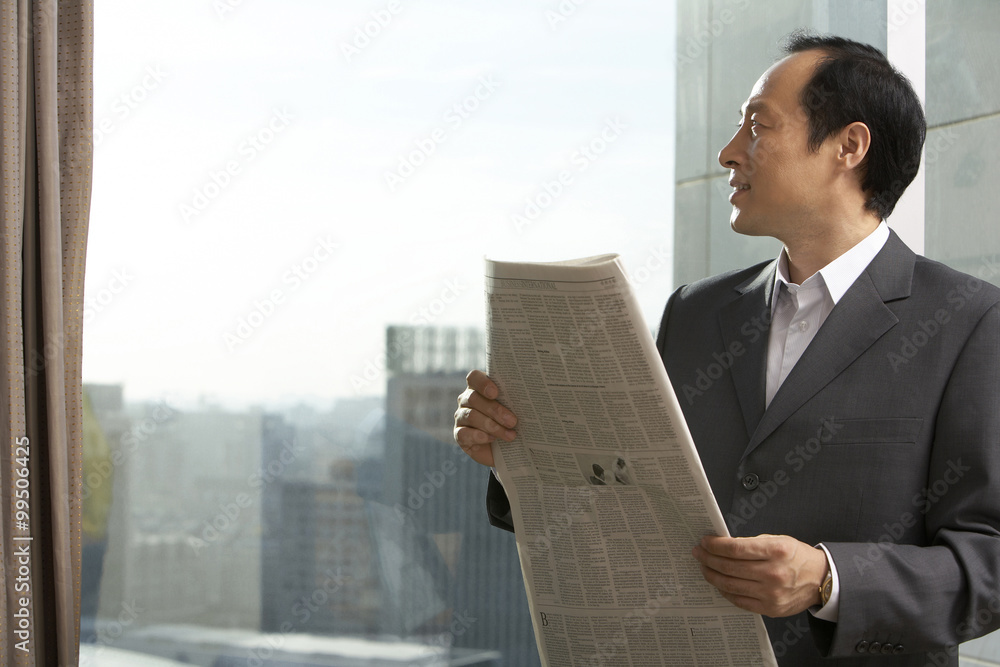 Man in business attire with newspaper