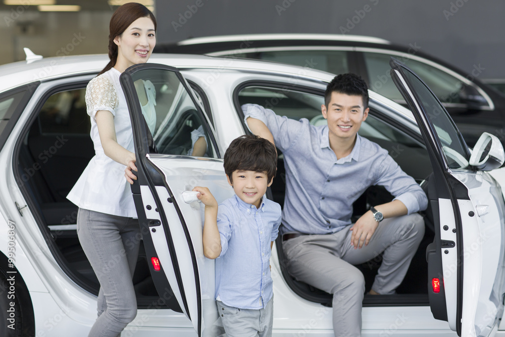 Young family choosing car in showroom