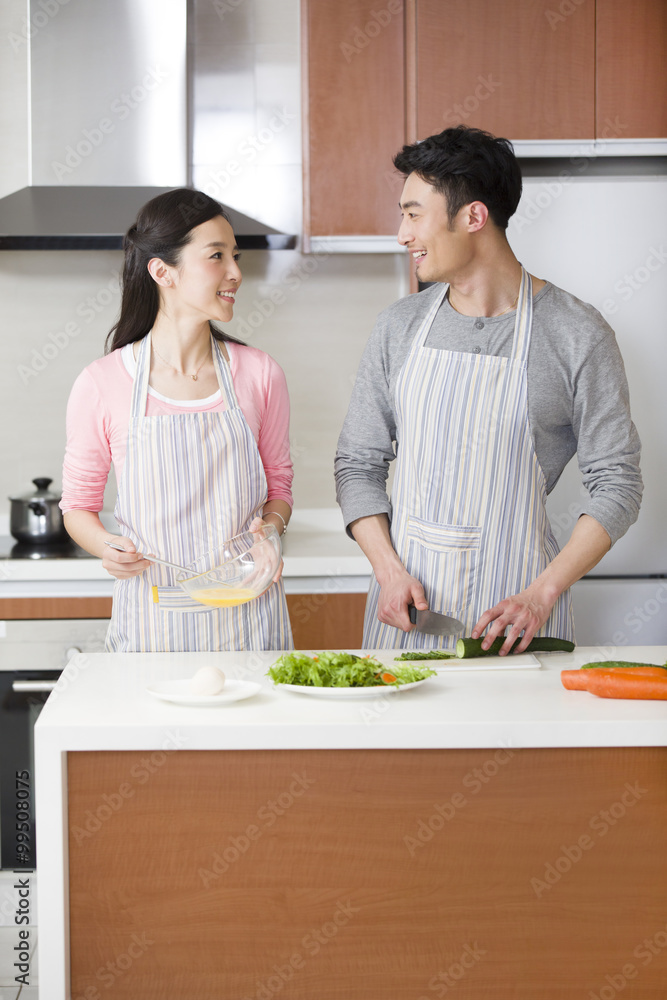 Happy young couple preparing meal