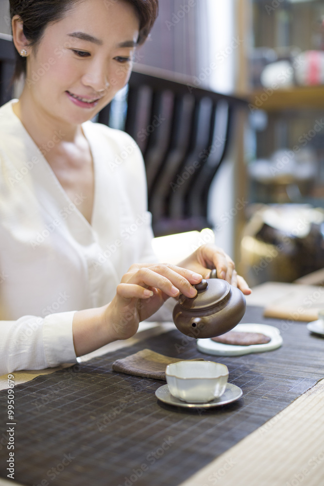 Mid adult woman performing tea ceremony