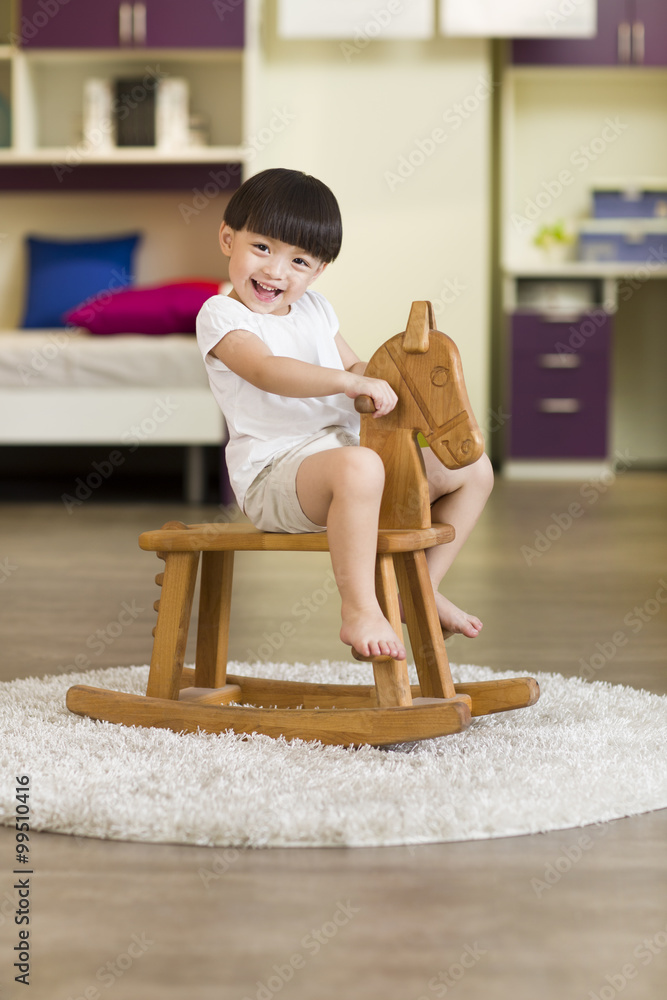 Young girl playing wooden horse chair