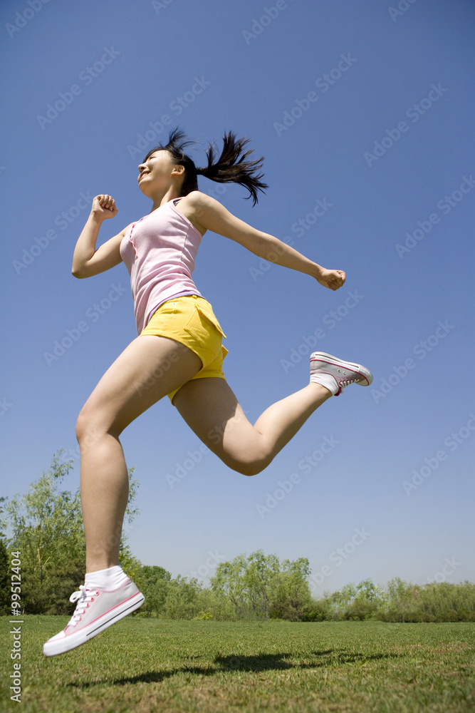 Young woman jumping in the air at the park