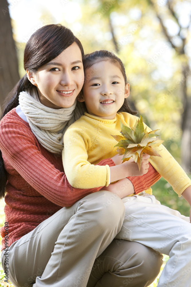 Mother and daughter collecting leaves