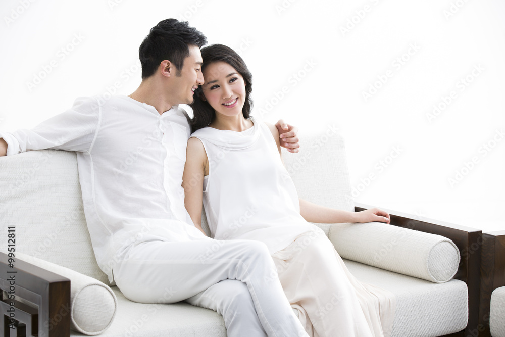 Happy young couple sitting on sofa