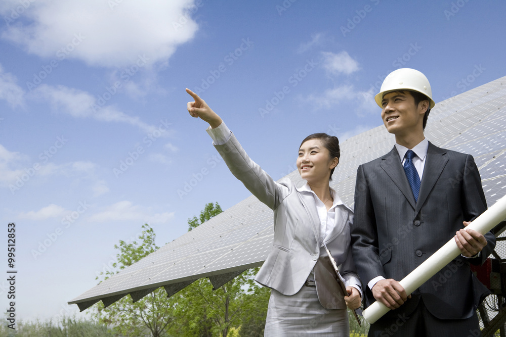 Two engineers in front of solar panels