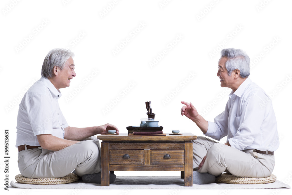 Male senior friends chatting over tea