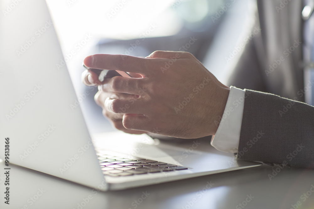 Businessman using smart phone and laptop