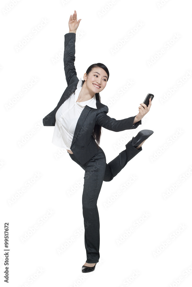 A dancing businesswoman holding a mobile phone