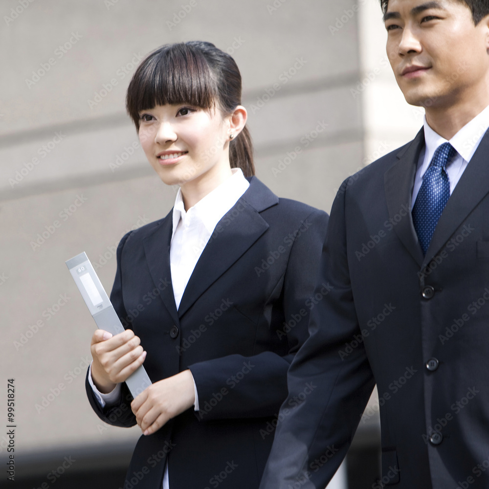 Two business professionals in front of skyscraper