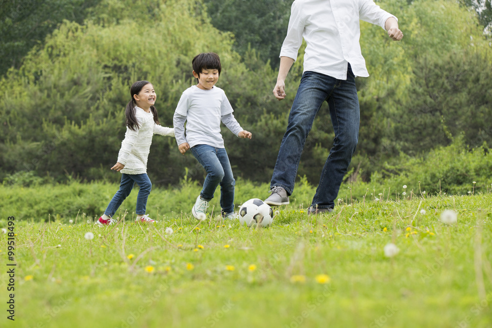 Happy father and children playing football together