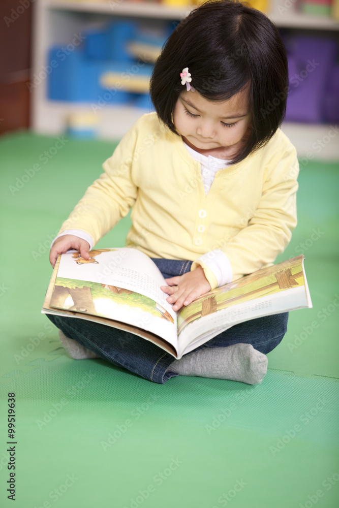 Cute little girl reading book