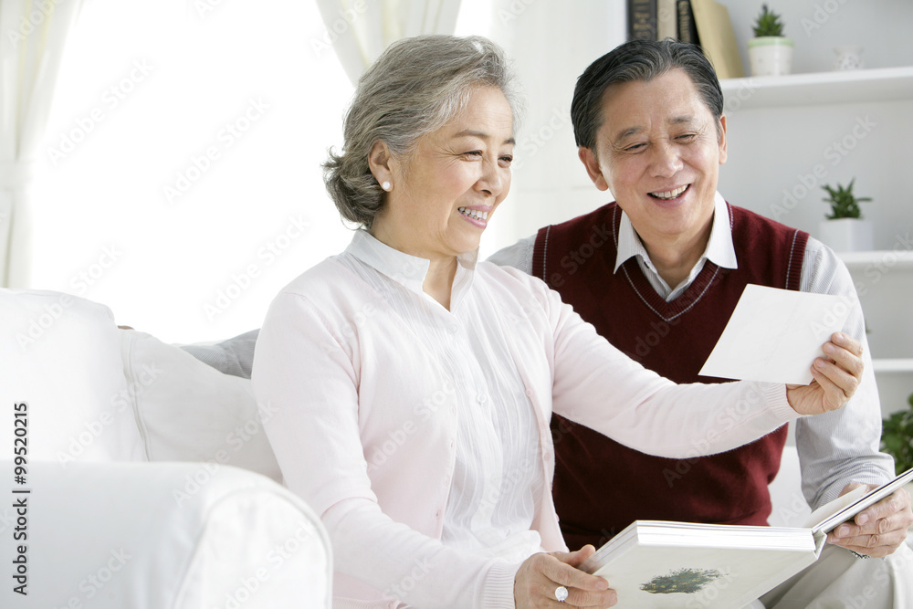 Senior Chinese couple looking at photo album