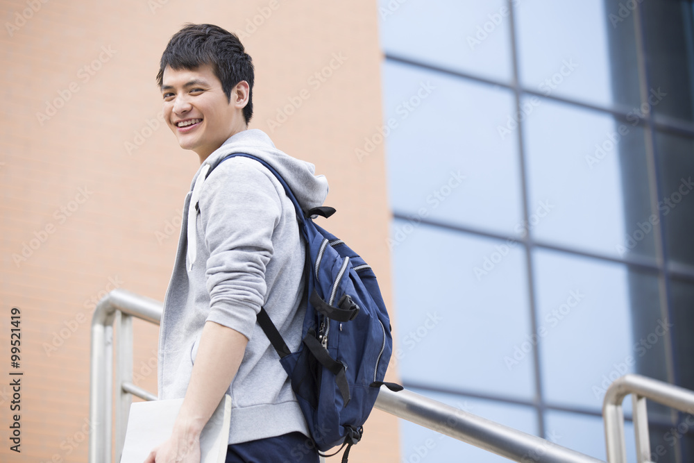 Male college student outside library