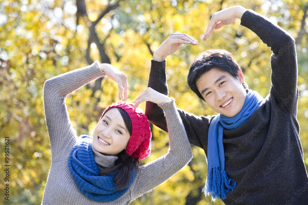 Young Couple Making Hearts with their Arms