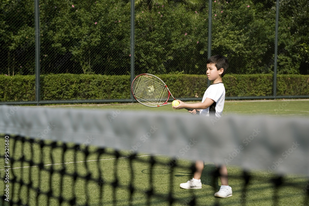 Young boy playing tennis