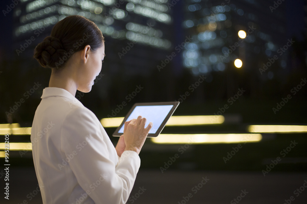 Businesswoman using digital tablet outdoors