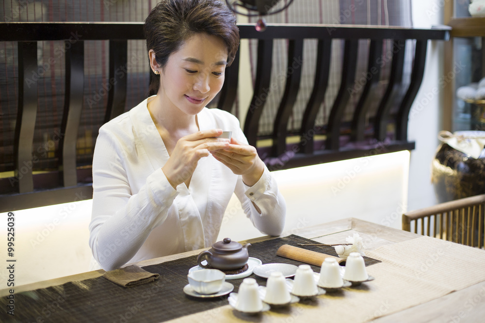 Mid adult woman performing tea ceremony