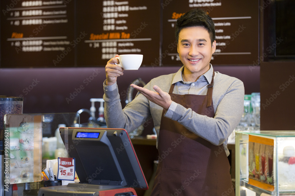 手里拿着一杯咖啡的男咖啡店店员