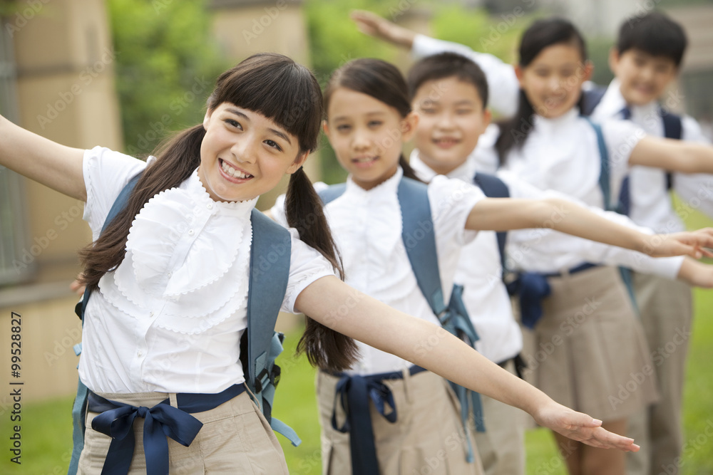 Lively schoolchildren in uniform playing at school yard