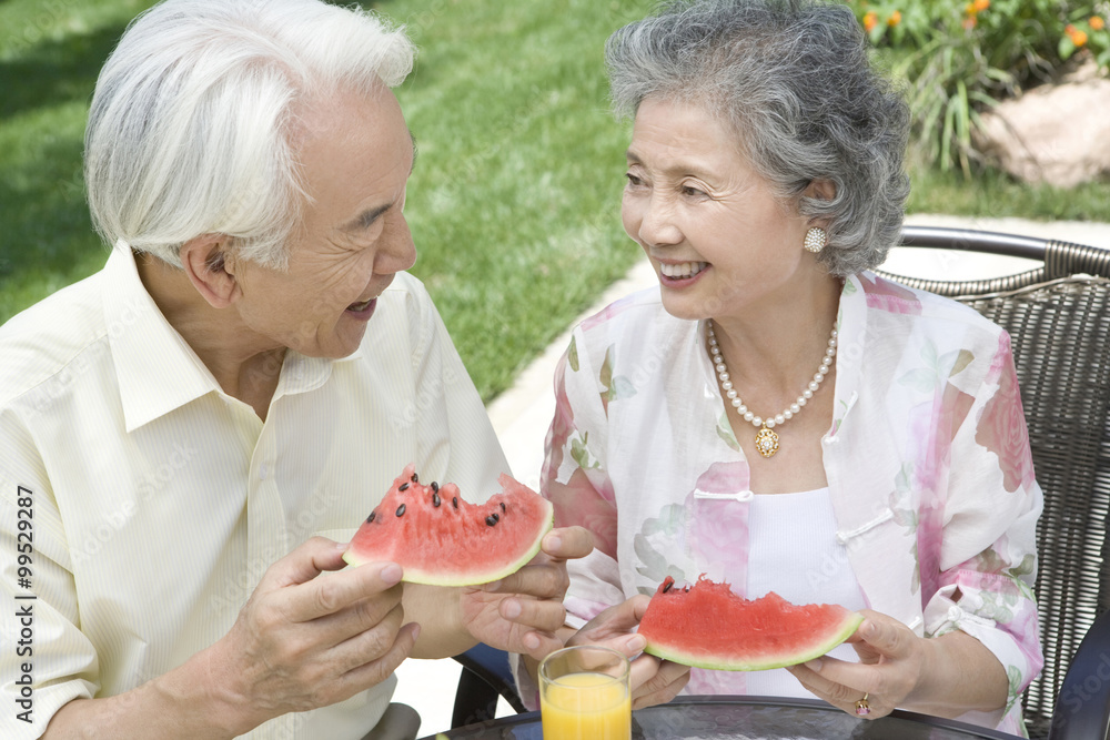 Senior couple eating watermelon