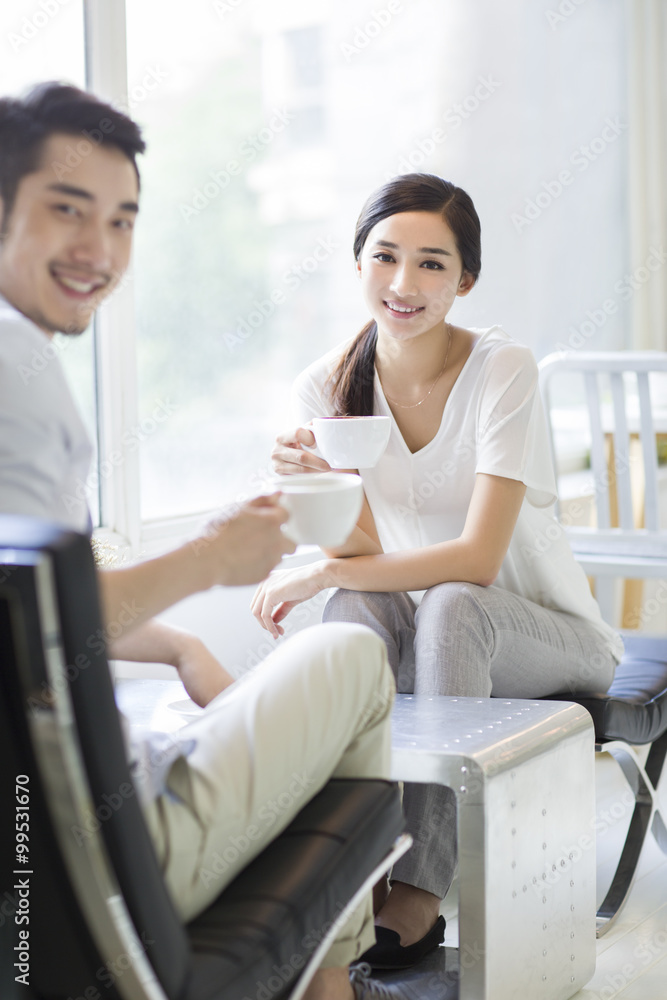 Happy young couple drinking coffee in coffee shop