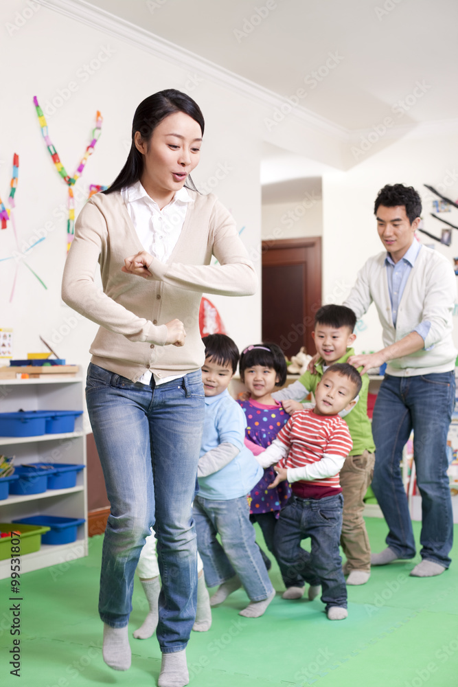 Happy kindergarten children and teachers playing games