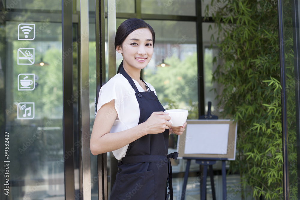 Shopkeeper standing in doorway of coffee shop