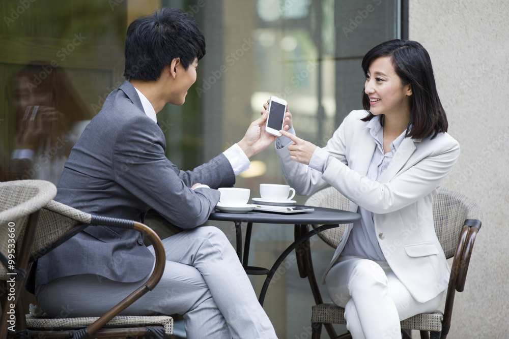 Two business person sitting at outdoor sidewalk café