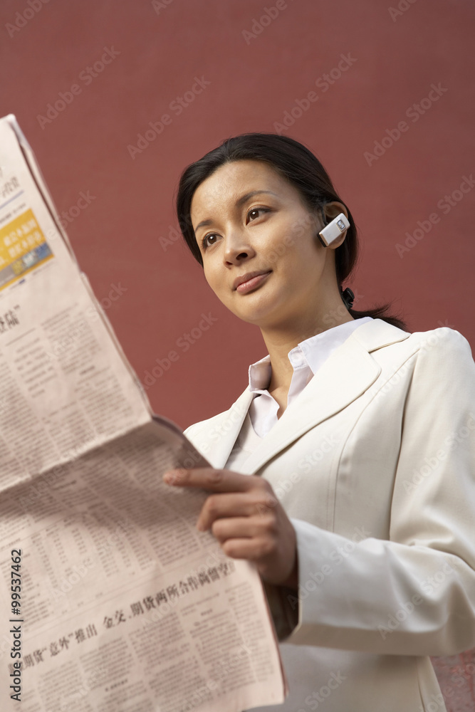 Young Businesswoman Reading Newspaper