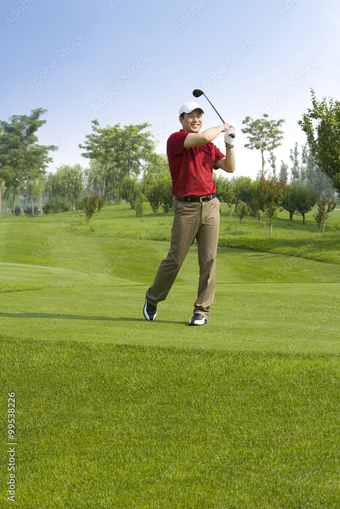 Male golfer swinging club