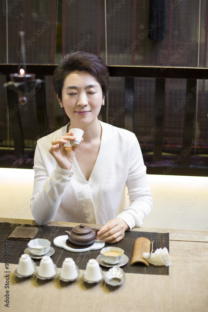 Mid adult woman performing tea ceremony