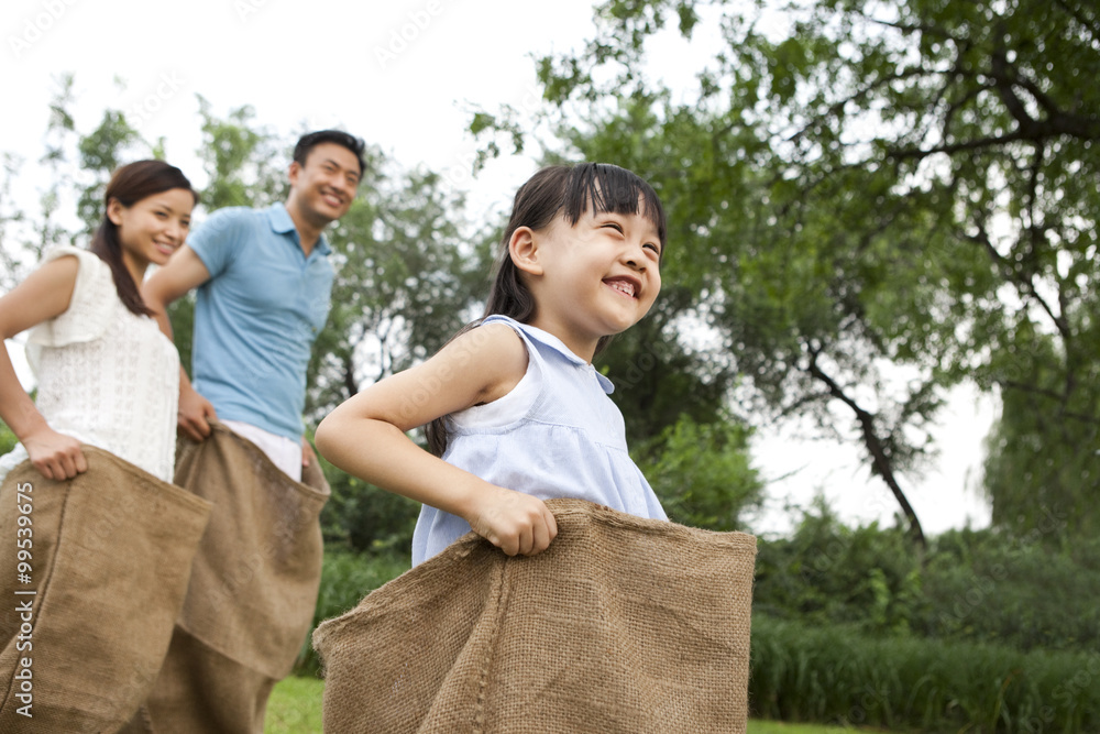 Cheerful family playing sack race