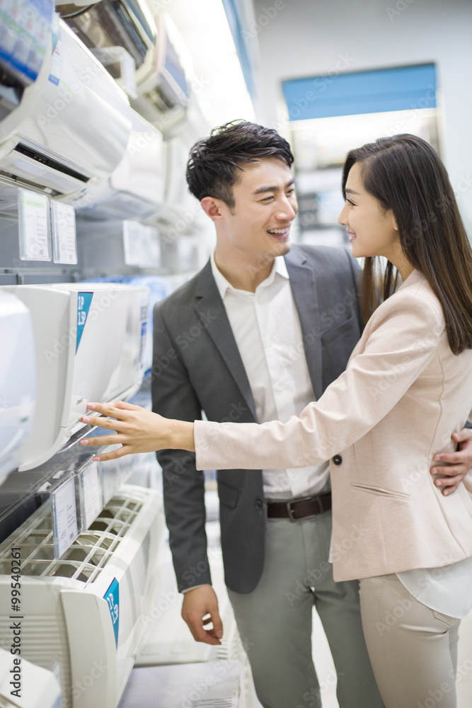 年轻夫妇在电子商店买空调