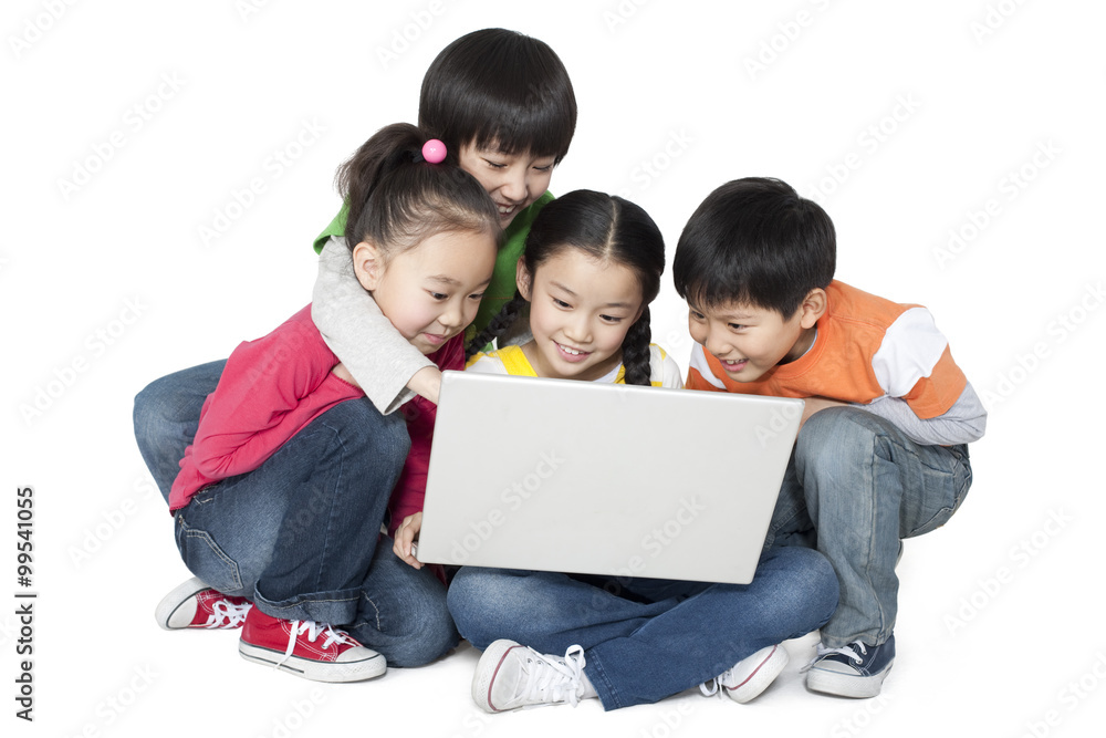 A group of children using a laptop together