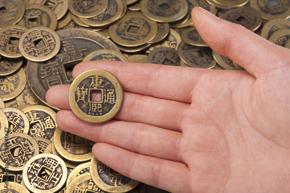 Hand holding traditional Chinese coin