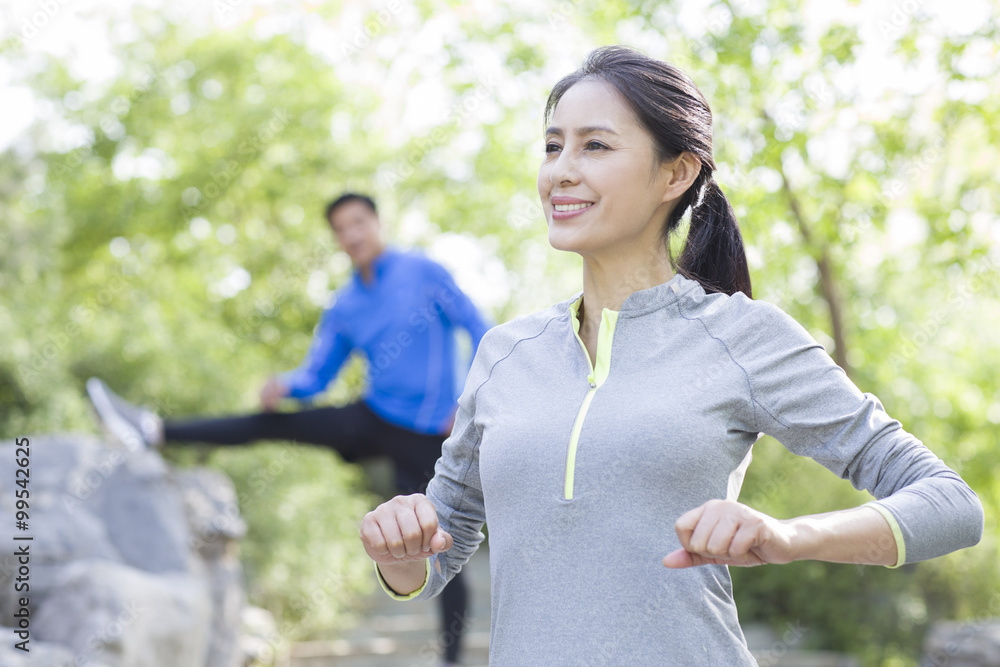 Happy mature woman exercising in park