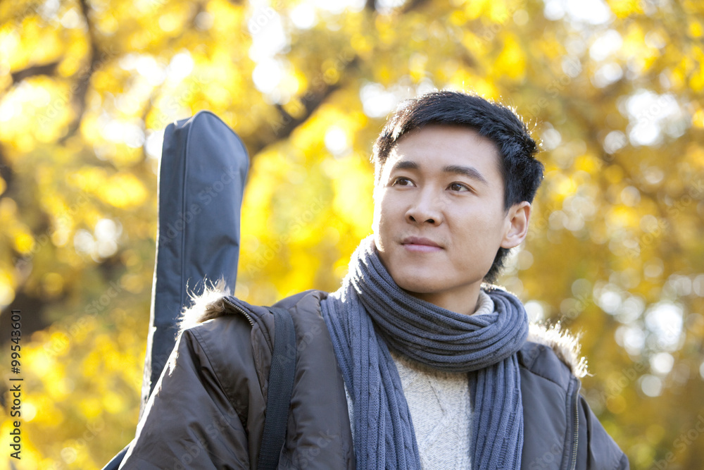 Young Man Carrying Guitar Case