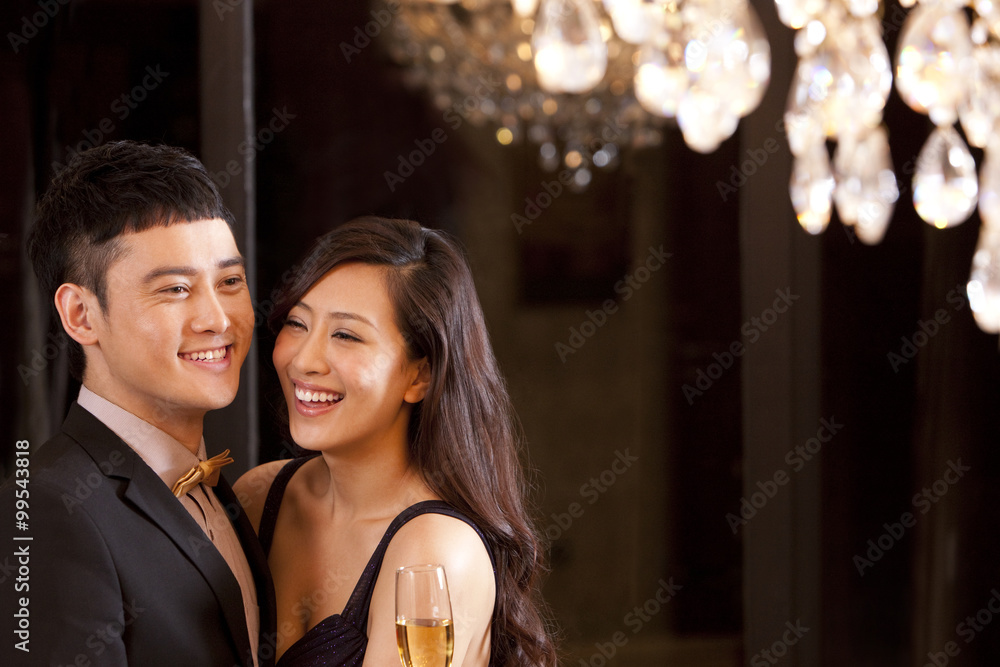 Young couple having champagne in a luxurious room