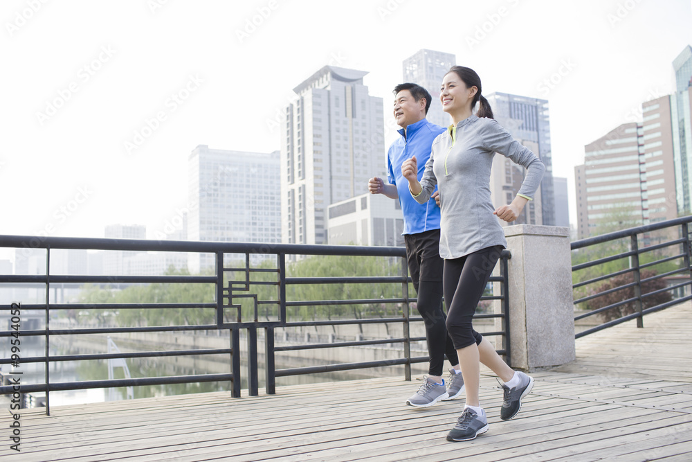 快乐的成熟夫妇在公园里跑步