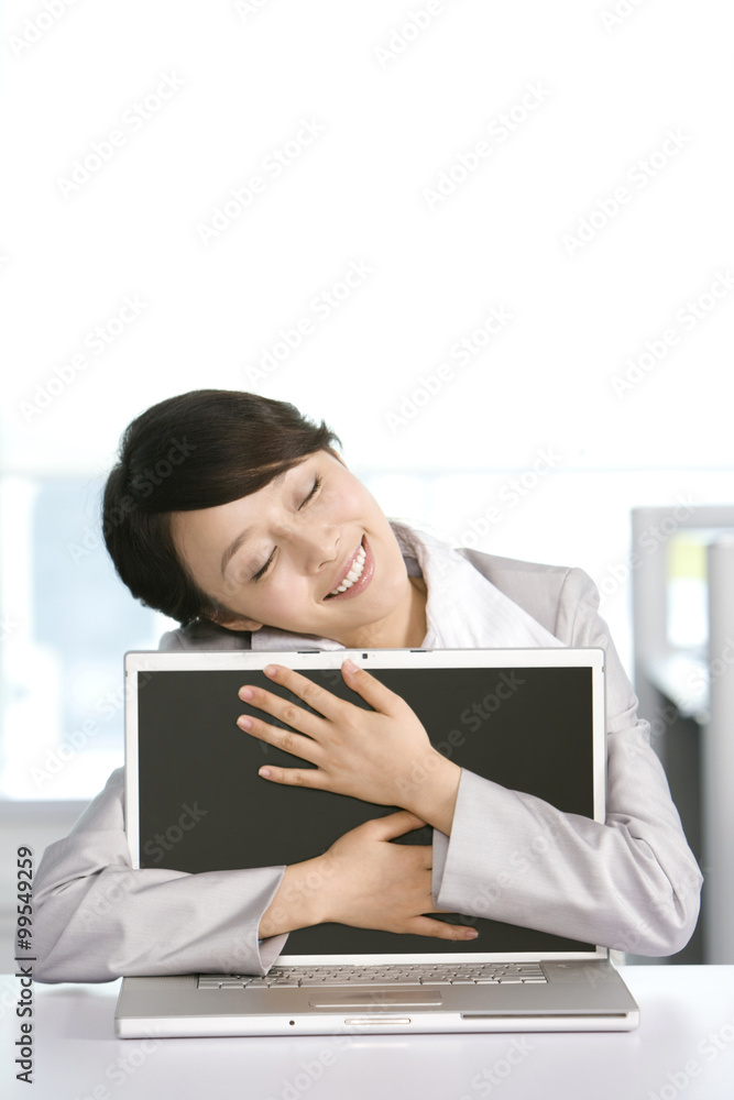 Office worker hugging her computer