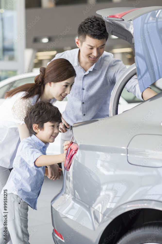 年轻家庭在展厅里看新车