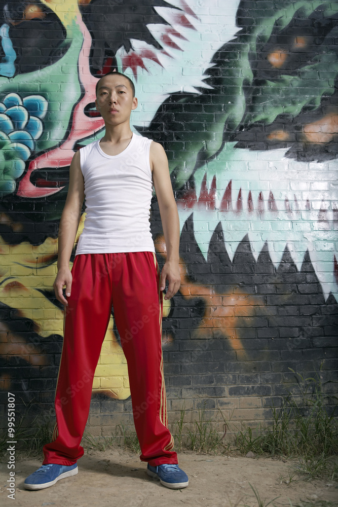 Teenage Boy Standing Next To Spray Painted Mural