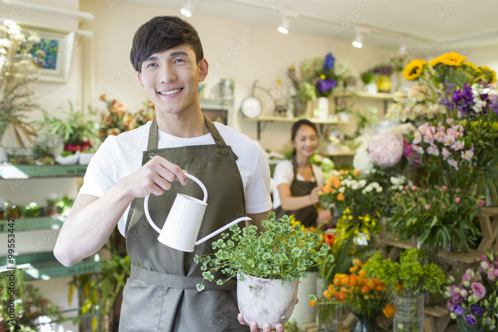 男花匠在花店给植物浇水