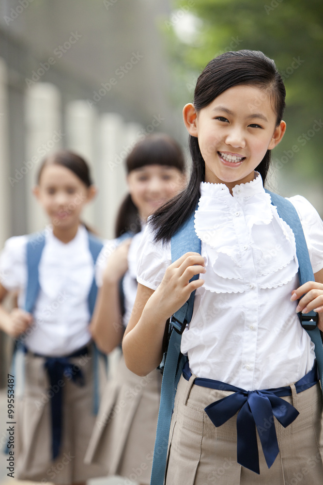 穿着制服的可爱女学生和她的朋友在后台