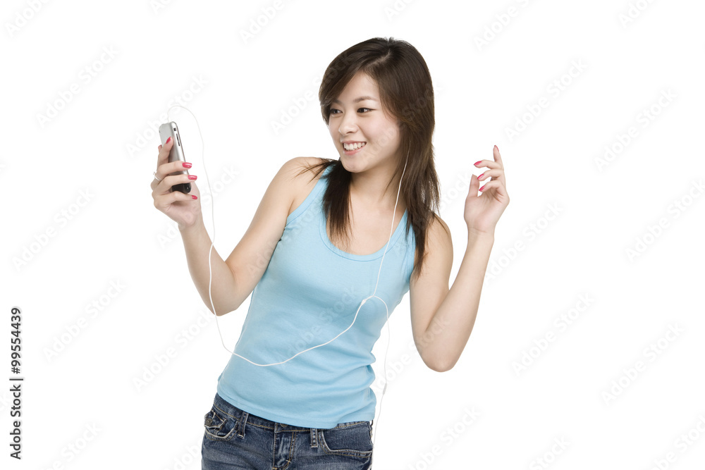 Smiling young woman listening to music on cell phone