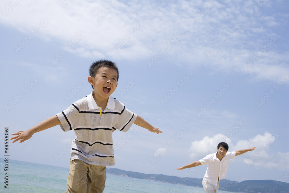 Father and son playing on the beach