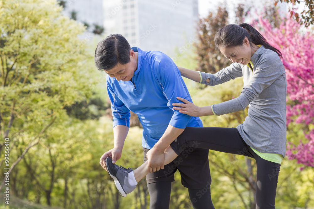 Happy mature couple exercising in park