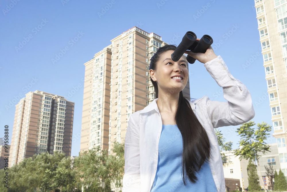 城市中的女人通过双筒望远镜