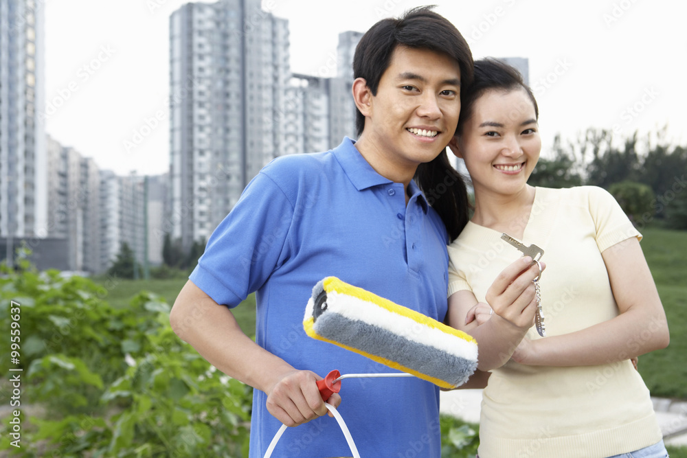 Woman And Man Holding A Paint Roller And Keys